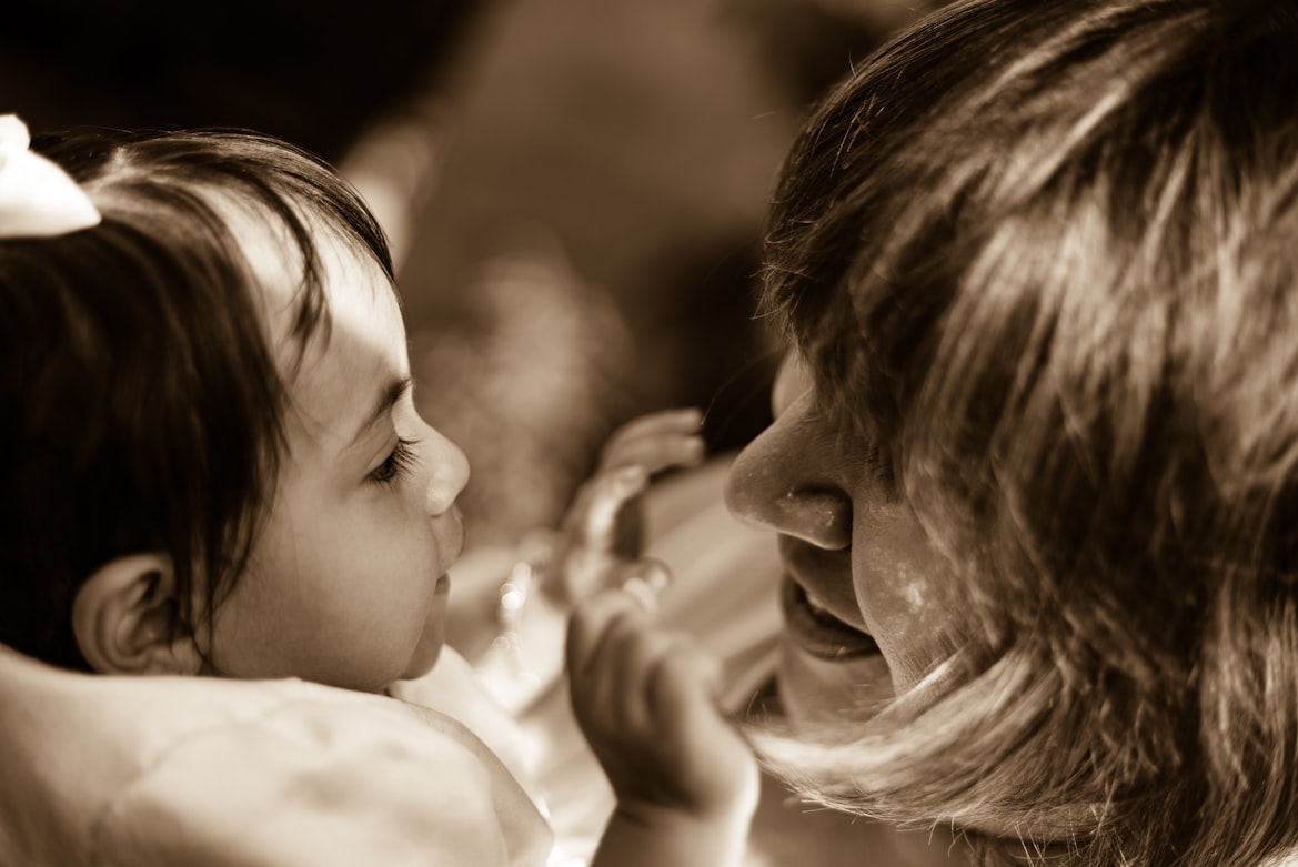 Madre leyendo un cuento a su hijo pequeño en casa